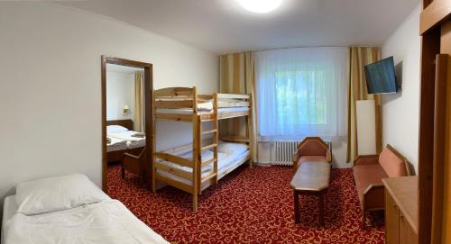 a bedroom with a bunk bed and a room with a bed and a desk at Hotel Stella in Železná Ruda