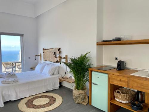 a bedroom with a bed and a desk with a sink at Villa Ioanna oliveproject in Plakias