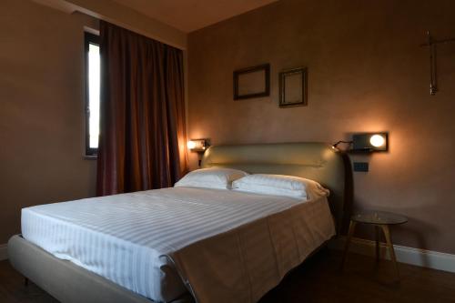 a bedroom with a bed with white sheets and a window at B&B Bricco della Guardia in Briaglia