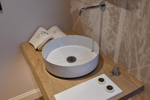 a bathroom with a white sink on a wooden table at B&B Bricco della Guardia in Briaglia