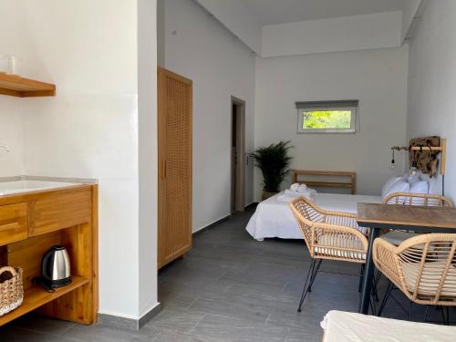 una camera con letto, tavolo e sedie di Villa Ioanna oliveproject a Plakiás