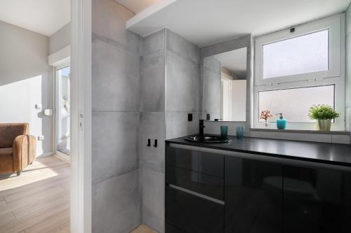 a bathroom with a black counter and a window at Natural Grey Albufeira in Albufeira