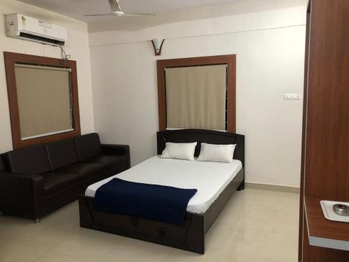a bedroom with a bed and a couch in it at Orchid Home in Bangalore