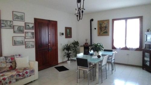 sala de estar con mesa, sillas y sofá en B&B da Sissi, en La Maddalena
