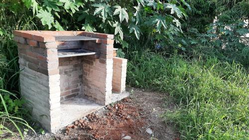 an outdoor brick oven sitting in the grass at Hostal a 10 min del centro de Veracruz in Veracruz