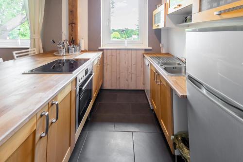 a kitchen with wooden cabinets and a white refrigerator at Bett im Bahnhof Güterschuppen keine JA oder ähnlich in Bad Harzburg