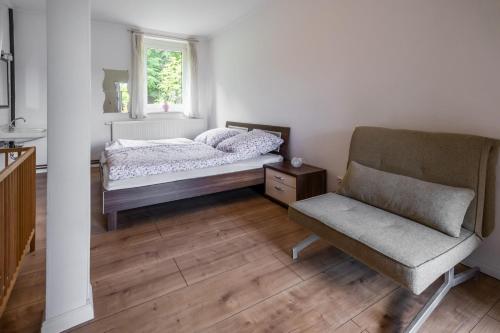 - une chambre avec un lit, une chaise et une fenêtre dans l'établissement Bett im Bahnhof Güterschuppen, à Bad Harzburg