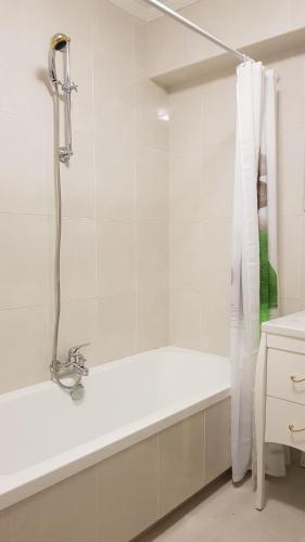 y baño blanco con ducha y bañera. en Apartamento Julieta, en San Vicente de la Barquera