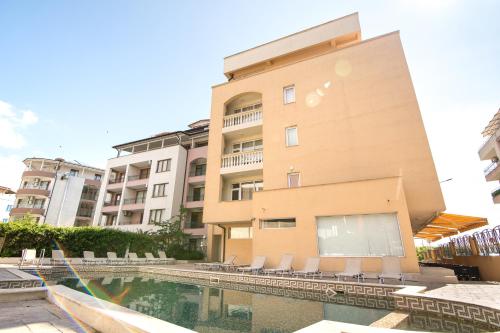a building with a swimming pool in front of a building at ТРОПИКАНА in Primorsko