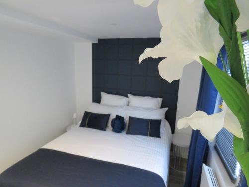 - une chambre avec un lit orné d'une grande fleur blanche dans l'établissement Le Modern'Blue entre centre ville et plage, à Mers-les-Bains