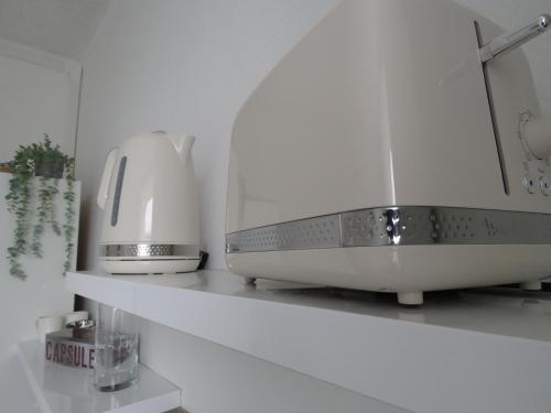 un comptoir de cuisine avec un grille-pain et un appareil sur une étagère dans l'établissement Le Modern'Blue entre centre ville et plage, à Mers-les-Bains