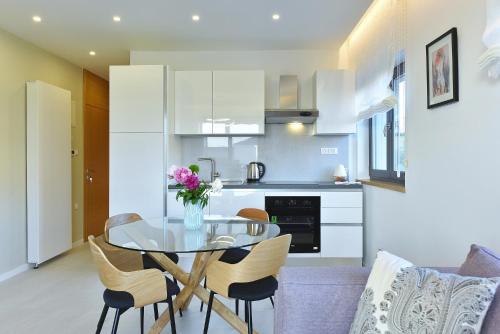 a kitchen and dining room with a glass table and chairs at Luxury Aparthotel Zadar in Zadar