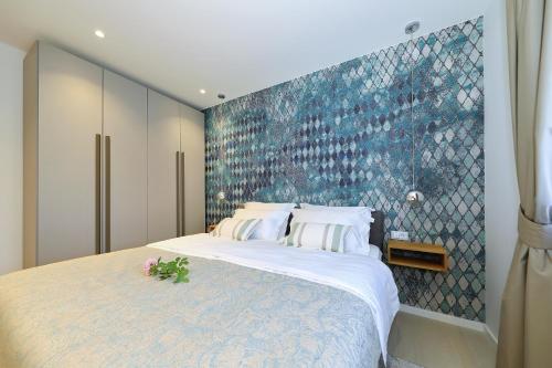 a bedroom with a large bed with a blue wall at Luxury Aparthotel Zadar in Zadar