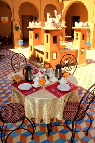a table with utensils and tea pots on it at Riad Dar Ouzine in Merzouga