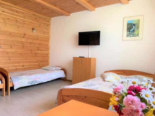 a room with two beds and a flat screen tv at Agro-Jaga in Święta Katarzyna
