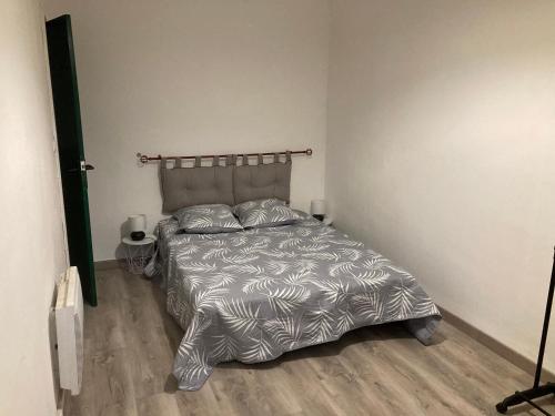 - une chambre avec un lit et une couette en argent dans l'établissement la provence 17 les horizons clairs chemin des passons, à Aubagne