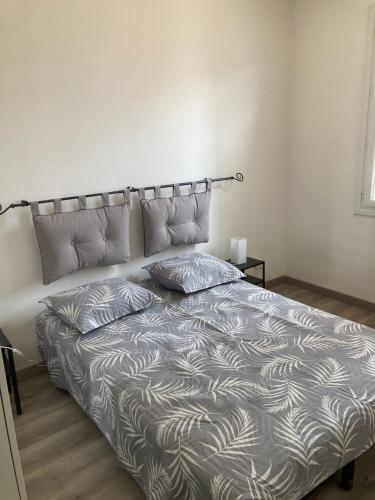 a bed in a white room with two pillows on it at la provence 17 les horizons clairs chemin des passons in Aubagne