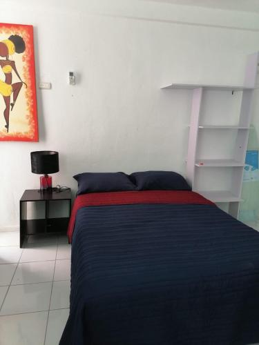 1 dormitorio con 1 cama con manta negra y mesa en Estudio full equipado, en Playa del Carmen