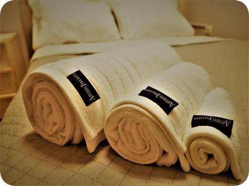 una pila di asciugamani appoggiata sopra un letto di Petite Palace Rotonda a Salonicco