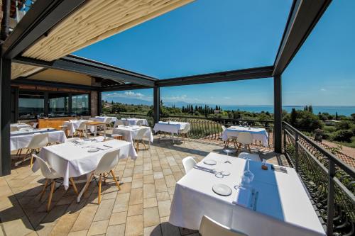 a restaurant with white tables and chairs on a balcony at H2O ROOMS in Moniga