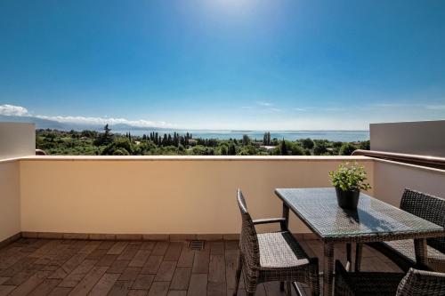 a balcony with a table and chairs and a view at H2O ROOMS in Moniga