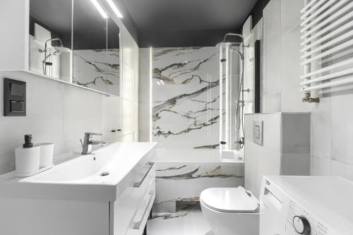 a white bathroom with a sink and a toilet at Apartament 888 Stare Miasto Apartamenty No 1 in Szczecin