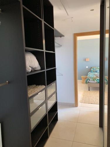 - un placard avec des étagères noires dans la chambre dans l'établissement Maison vue mer Propriano Viggianello, à Viggianello