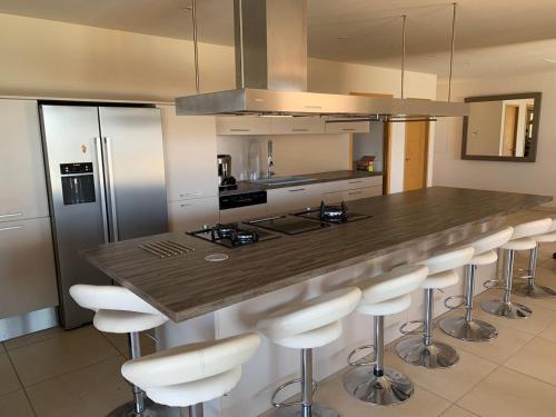 une cuisine avec un comptoir et des tabourets. dans l'établissement Maison vue mer Propriano Viggianello, à Viggianello