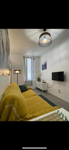 une chambre avec un lit avec une couverture jaune dans l'établissement New! Charmant T2 idéalement situé au coeur du centre historique., à Aix-en-Provence