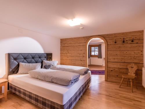 1 dormitorio con 2 camas y pared de madera en Ferienwohnungen-Gästehaus Altginzling en Ginzling