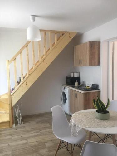a living room with a table and a staircase at Apartament Pod Wiśnią in Supraśl