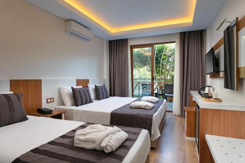 a hotel room with two beds and a balcony at Le Marden Hotel Spa in Tekirova