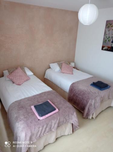 two beds sitting in a room with at Apartament Pod Wiśnią in Supraśl