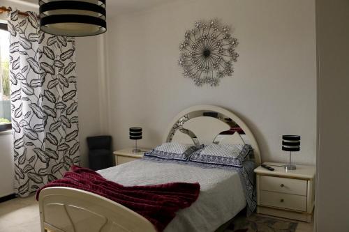 a bedroom with a bed and a mirror on the wall at Casa Teresinha in Sesimbra