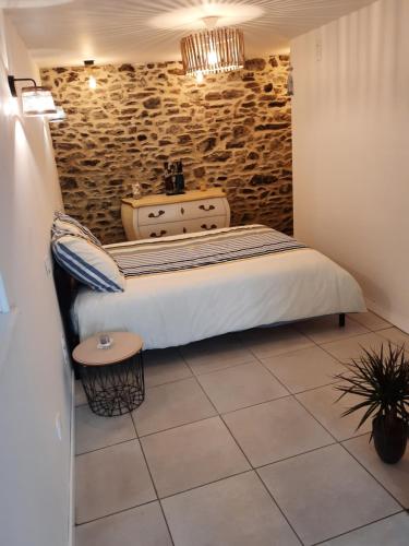 a bedroom with a bed and a stone wall at Granville plage normandie mont saint Michel in Granville