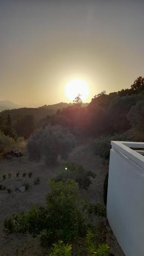 a sunset in a field with a white refrigerator at Studio Vasileios-The Best Luxury Guest Room in Spili in Spílion