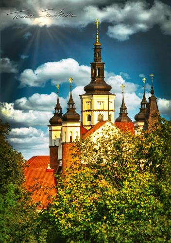 a building with a clock tower on top of it at Apartament Pod Wiśnią in Supraśl