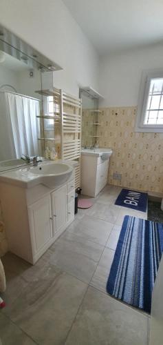 une salle de bain avec un lavabo, une baignoire et un miroir dans l'établissement Sojeaflor, à Coutras