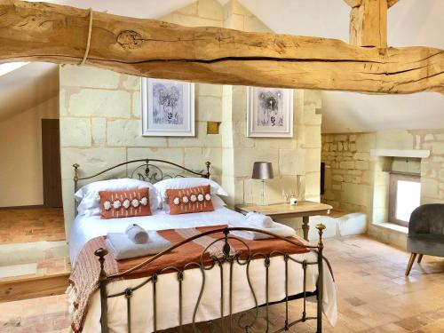 a bedroom with a bed in a stone wall at Maison de Lavande in Ranton