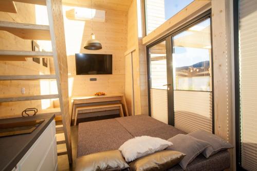 um pequeno quarto com uma cama e uma janela em MAXI SONCE, Odprte vasi em Prvačina