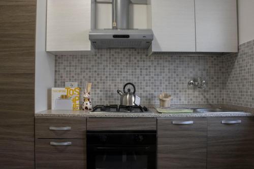 a kitchen with white cabinets and a tea kettle on the stove at La tana dello zio Gio in Endine Gaiano