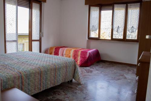 a room with two beds and two windows at La tana dello zio Gio in Endine Gaiano