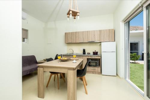 a kitchen and dining room with a wooden table and chairs at Sagma Villas in Perissa