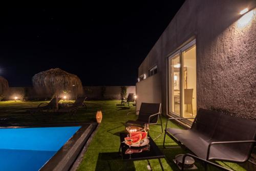 a villa with a swimming pool at night at Sagma Villas in Perissa