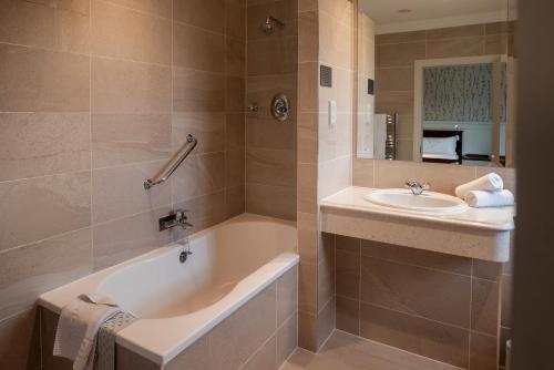 a bathroom with a tub and a sink at Whitford House Hotel in Wexford
