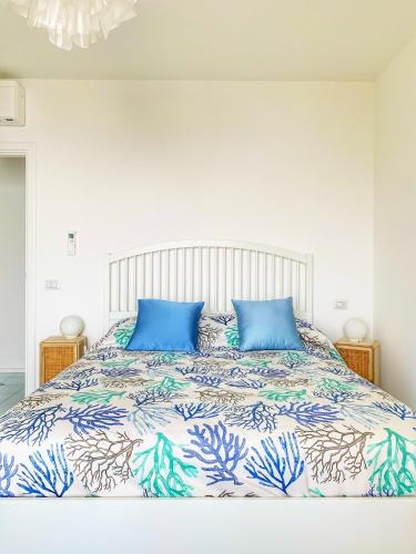 a bedroom with a large bed with blue pillows at Casa Ministro in Positano