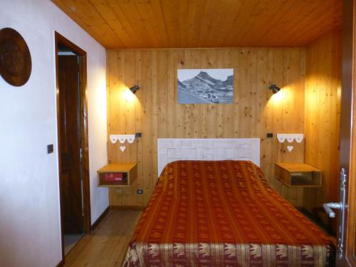1 dormitorio con 1 cama en una habitación de madera en Les Saisies coté Légette appartement dans chalet LE NEPAL, en Les Saisies