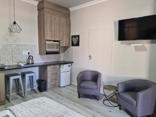 una cucina con due sedie e un piano di lavoro di Royal Apartments Kimberley a Kimberley