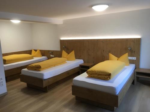 Habitación con 2 camas con almohadas amarillas en Gasthaus Storchen, en Waldshut-Tiengen