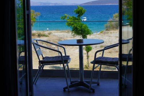 a table and chairs on a balcony with a view of the ocean at Angelo Hotel-Cafe in Tolo